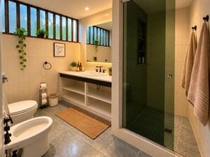 Ein Badezimmer mit Toilette, Bidet, Waschbecken und Dusche.