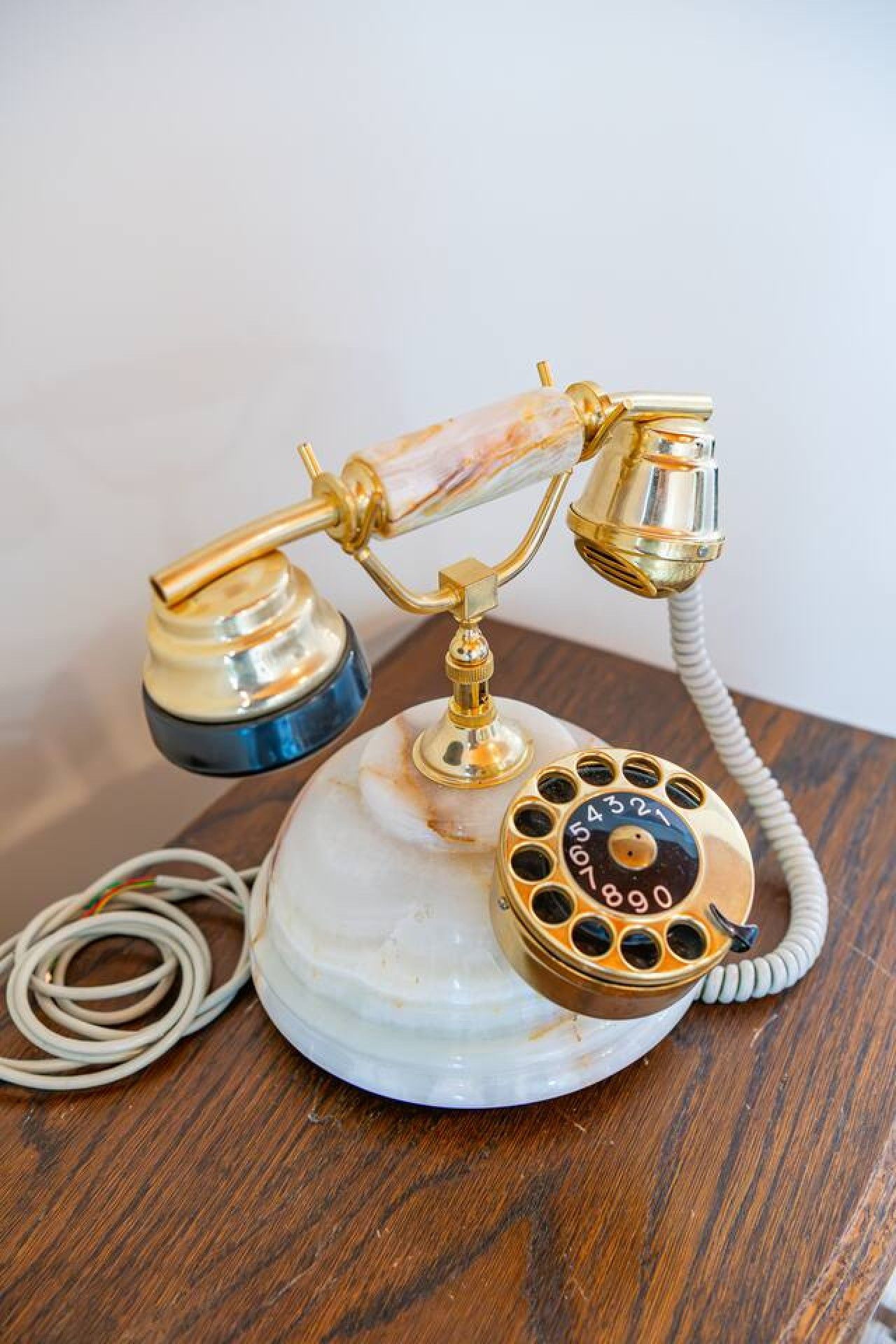 En gammal telefon med en fot av marmor och en spiralformad sladd.