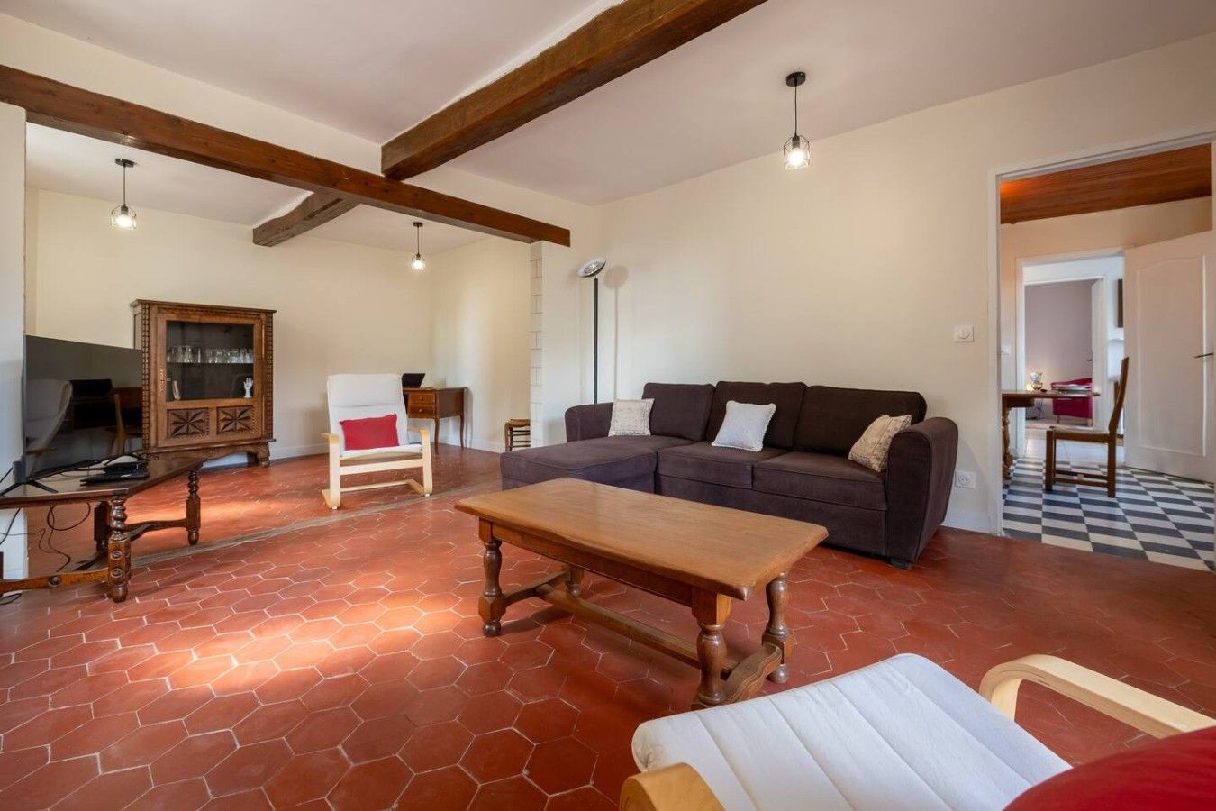 Un salon spacieux avec un canapé, une table basse en bois et un téléviseur.