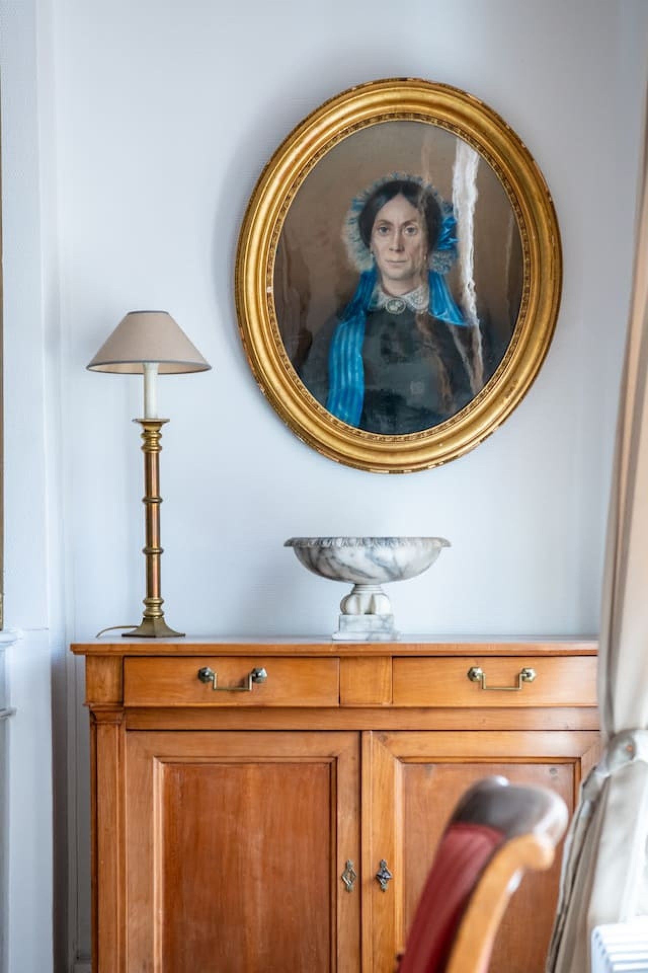 Een houten kast met lades en een spiegel erboven.