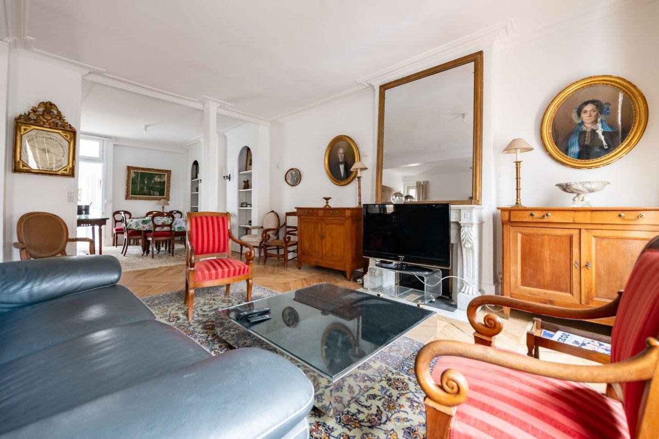 Un salon avec un canapé, des fauteuils, un téléviseur et une cheminée.