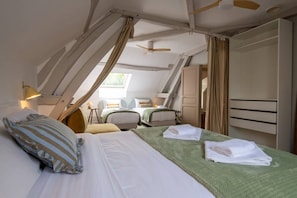 Un dormitorio con cama, mesitas de noche, escritorio y armario.