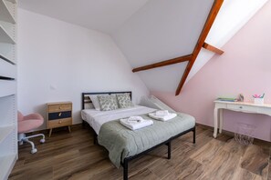 A bedroom with a bed, a desk, a chair, and a slanted ceiling. - Le Panoramique | Exceptional Home • 12 trips (Crécy-la-Chapelle)