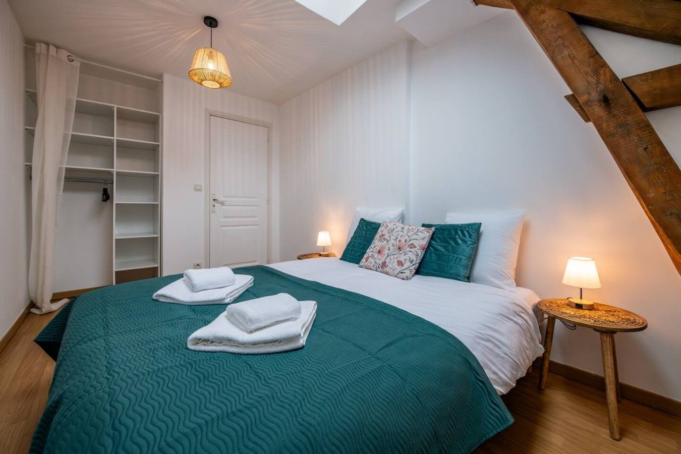 Ein Schlafzimmer mit einem Bett, zwei Nachttischlampen, einem Kleiderschrank und einer Deckenleuchte.