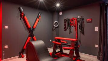 A gym with exercise equipment, including a bench and weightlifting machines.