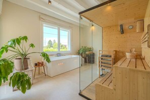 Un baño moderno con cabina de ducha de vidrio, bañera y elementos de madera.