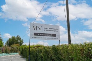 Une enseigne indique « Chez MV », un hôtel doté d’un site web, et précise qu’il est possible de réserver en ligne et que l’accès se fait de manière automatisée.