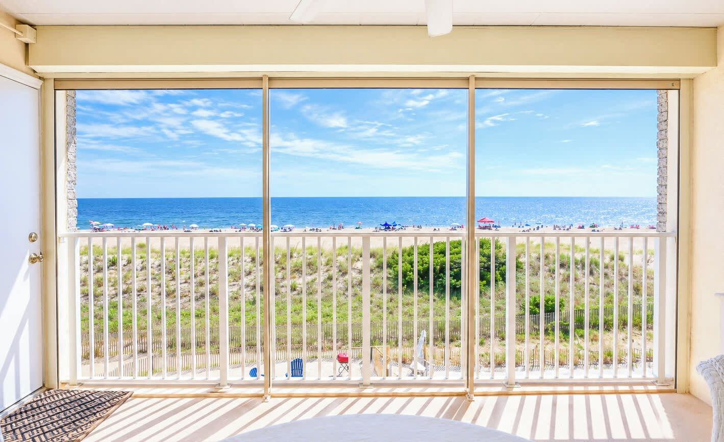 A balcony with a view of a beach and ocean.