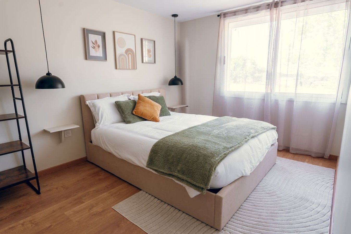 Une chambre à coucher avec un lit, une échelle, une étagère et une fenêtre avec des rideaux.