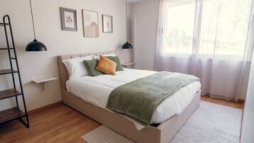 Une chambre à coucher avec un lit, une échelle, une étagère et une fenêtre avec des rideaux.