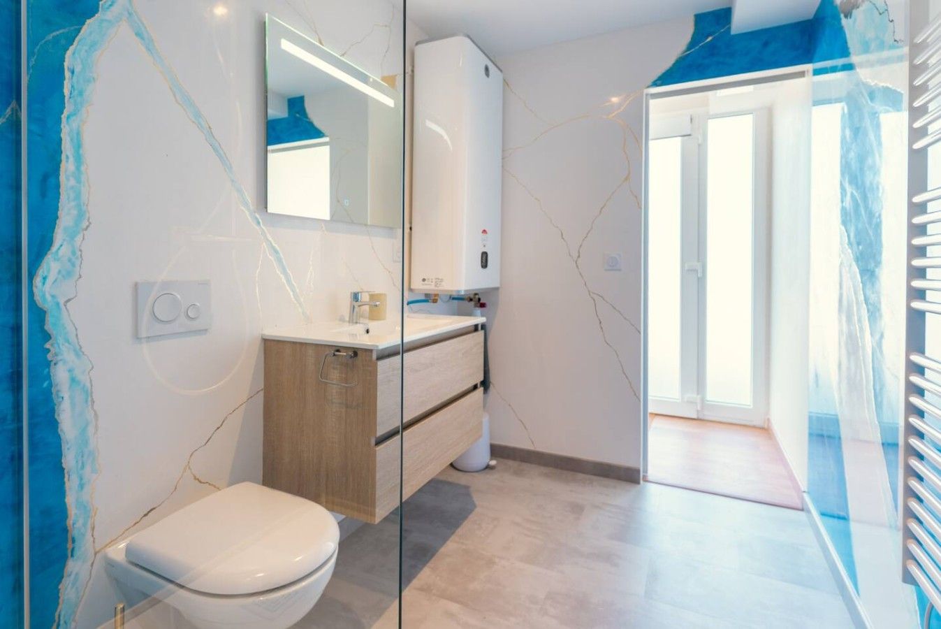 Ein modernes Badezimmer mit Toilette, Holzwaschtisch und einer Duschkabine aus Glas.