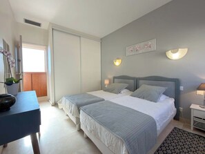 A bedroom with two beds, a desk, and a potted plant. - Beachfront 3 Bedroom Apartment with Panoramic Sea View and Balcony (Valras-Plage)