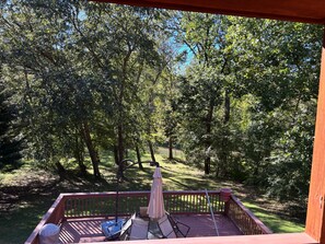 Eine Terrasse mit Gartenmöbeln, einem Picknicktisch und einem Schirm.