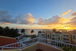 Ein Hotelbalkon mit Blick auf den Ozean und Sonnenuntergang.