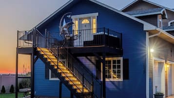 Une maison à deux étages avec un balcon, un escalier et un garage.