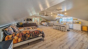 A spacious loft with a large bed, a kitchen area, and a dining space. - Kieckhaefer Acres - Honey House (Grand Junction)