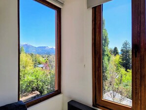 A room with two large windows offering a view of a mountainous landscape and a forested area. - #7 Modern Loft with Fast WiFi, Great for Remote Work. 300 m from the Lake (San Carlos de Bariloche)