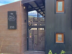 A modern building with a sign for 'Palo Santo Apartments' and the number 233. - #7 Modern Loft with Fast WiFi, Great for Remote Work. 300 m from the Lake (San Carlos de Bariloche)