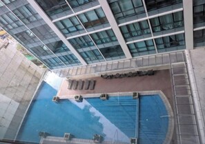 Ein modernes Gebäude mit großer Glasfassade, einem Schwimmbecken und einem Schild mit der Aufschrift 'Quinta de la'.