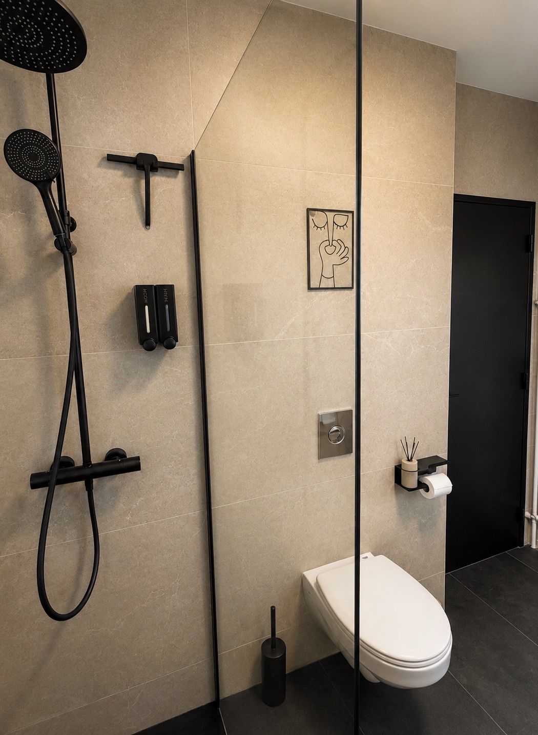 Une salle de bain moderne équipée d’une douche, de toilettes et d’un porte-serviettes.