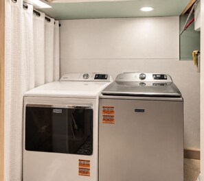 Un área de lavandería con dos lavadoras Maytag y una secadora.