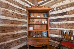 A wooden bookcase with multiple shelves, a red bench, and a rustic wooden wall. - Historic Cabin w/King Bed + Walk to Wineries! (Fredericksburg)