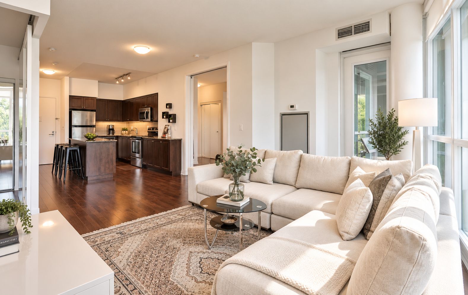 A modern living room with a sofa, coffee table, and a view of the kitchen.