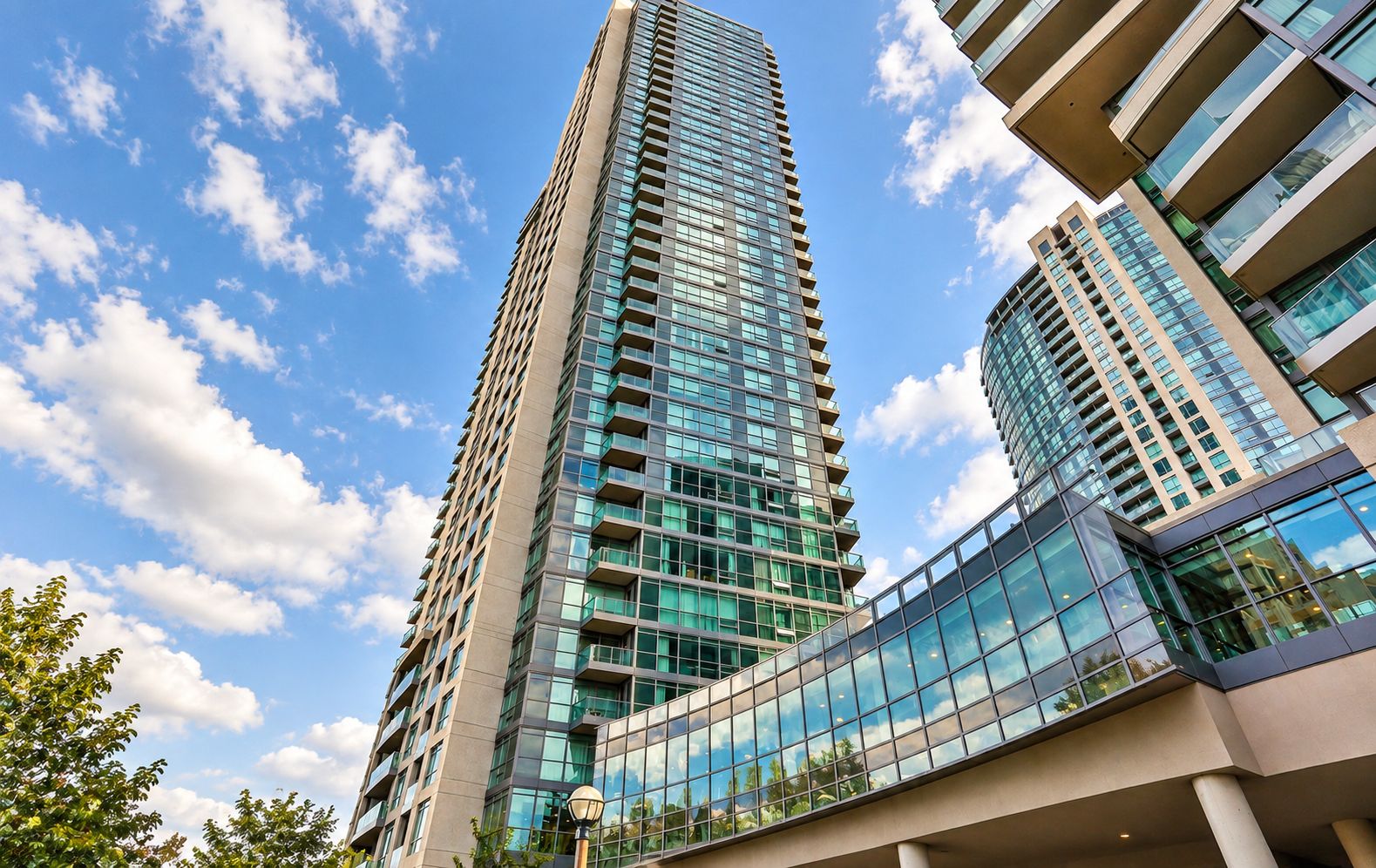 A high-rise building with a modern architectural design, featuring a glass facade and multiple balconies.