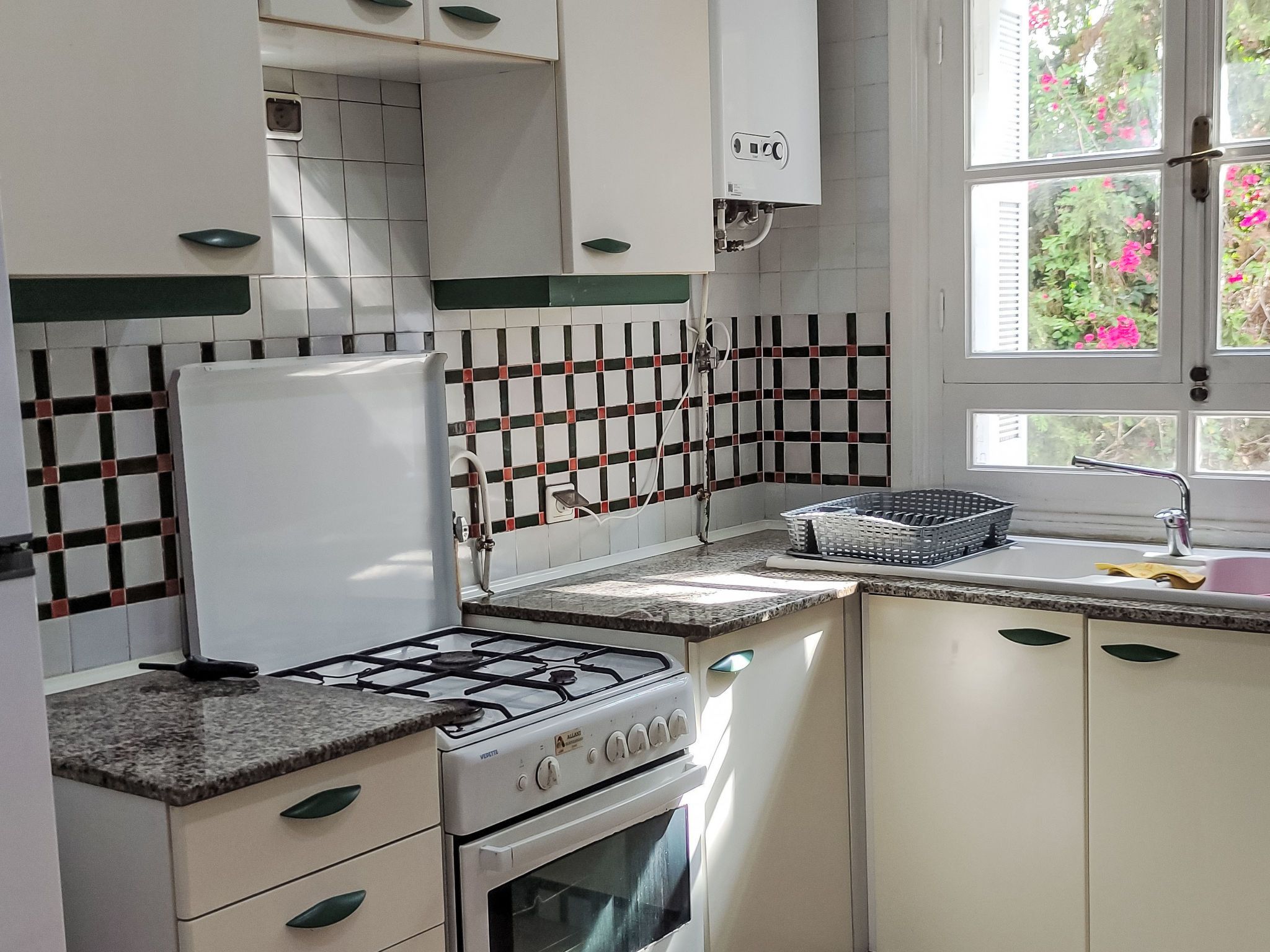 A kitchen with white cabinets, a gas stove, and a tiled backsplash.