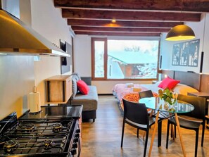 A modern interior with a kitchen, dining area, and a sofa with a view. - #3 Monoambiente, buena vista, excelente wifi (San Carlos de Bariloche)