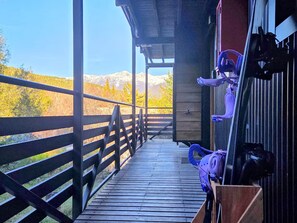 A wooden deck leading to a building with a view of mountains and autumn foliage. - #3 Monoambiente, buena vista, excelente wifi (San Carlos de Bariloche)