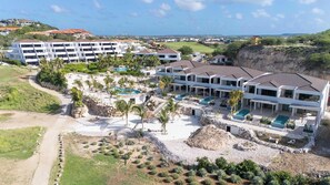 A resort with multiple buildings, a swimming pool area, and a view of the surrounding landscape. - Solara - Luxury 3-Bedroom Home with Private Pool (Willemstad)