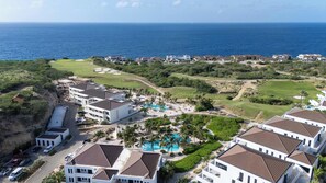 Un complexe hôtelier comprenant plusieurs bâtiments, une piscine et offrant une vue sur l’océan.