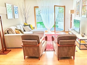 A living room with a sofa, two armchairs, a coffee table, a TV, and a large window with curtains. - Chesa Altrova by Interhome (St. Moritz)