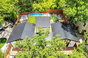 Ein Wohnhaus mit Swimmingpool, zwei separaten Garagen und einem Garten mit Terrasse.