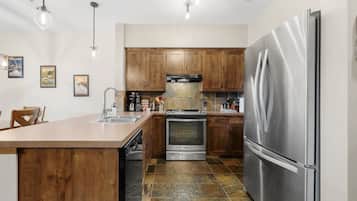 Une cuisine moderne avec des meubles en bois, des appareils électroménagers en acier inoxydable et un îlot central.