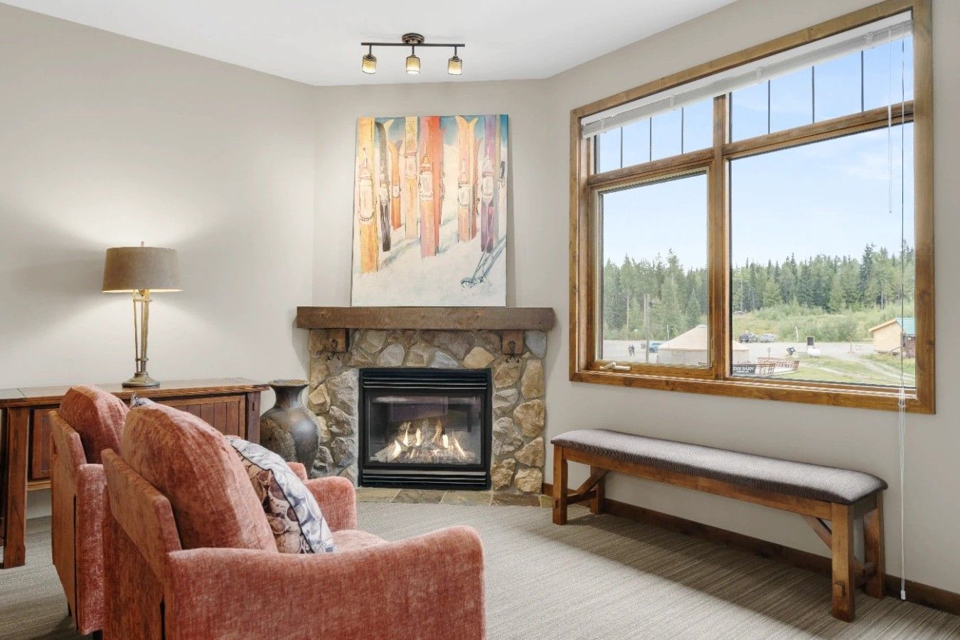 A living room with a fireplace, a bench, a sofa, and a painting on the wall.