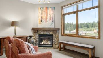 A living room with a fireplace, a bench, a sofa, and a painting on the wall.