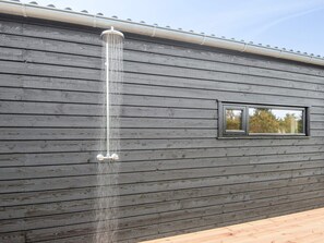 A wooden exterior wall with a window and a vertical water feature. - 5 Star Holiday Home in Romo (Rømø)