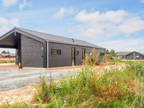 A modern building with a sloped roof and a covered entrance. - 5 Star Holiday Home in Romo (Rømø)