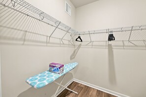 A laundry area with a drying rack, ironing board, and hanging clothes. - Brilliant 3-bedroom house with AC near ocean Isl Bch (OCEAN ISL BCH)