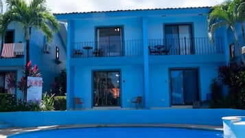 A two-story hotel with a swimming pool in front.