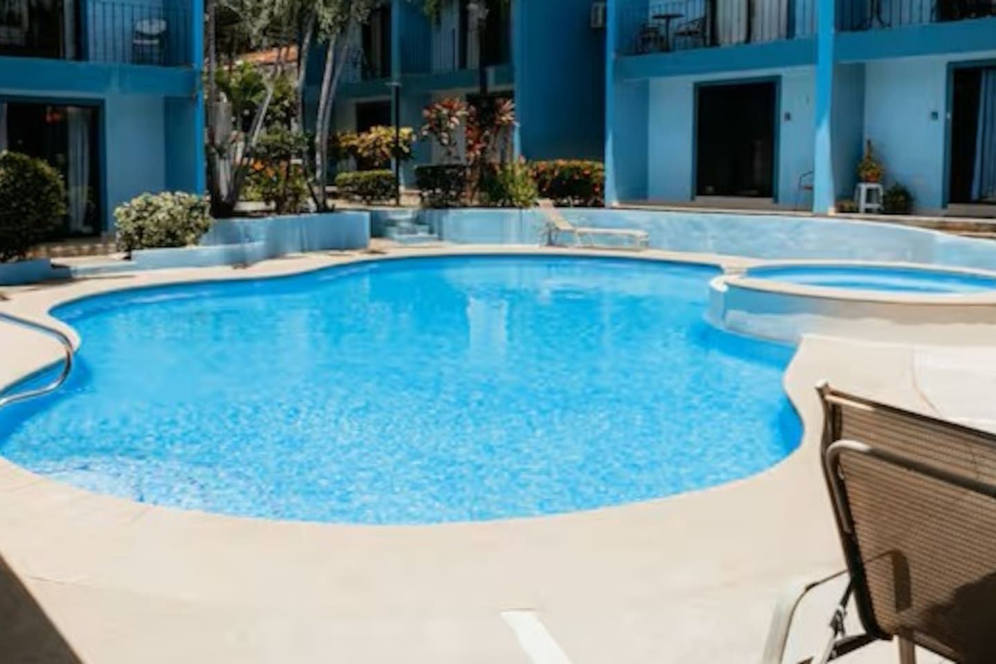A swimming pool with a curved edge, surrounded by a concrete deck.