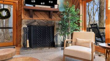 A cozy interior with a fireplace, a comfortable chair, and a view of the outdoors.