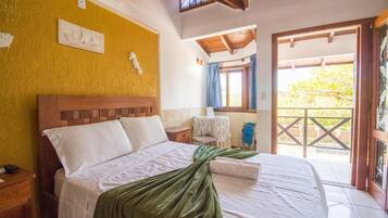 Ein Hotelzimmer mit Bett, kleinem Tisch und Blick ins Freie.