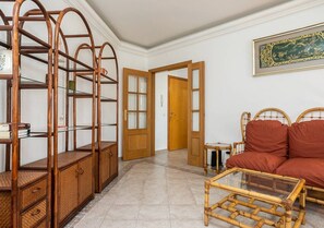 A room with a sofa, a glass-top coffee table, and a wooden cabinet with drawers. - Casa das Chaminés – In Conceicao de Tavira (Tavira)