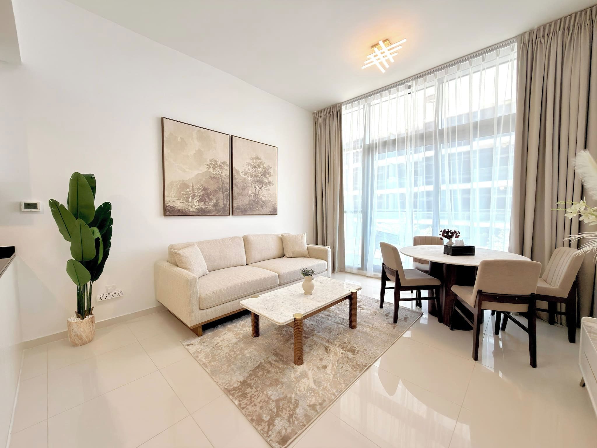 A modern living room with a sofa, coffee table, and dining area.