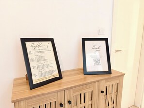 Zwei gerahmte Willkommens- und Dankesschilder an einem Holzschrank.