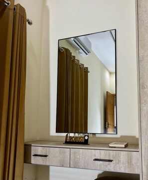 Casa de banho com espelho, porta-toalhas e armário com a inscrição 'ROBUST'.