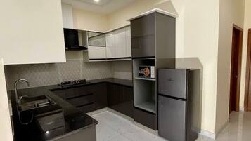 A modern kitchen with a built-in stove, a refrigerator, and a microwave.